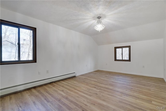 bonus room featuring light hardwood / wood-style floors, plenty of natural light, and a baseboard heating unit