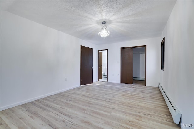 unfurnished bedroom featuring a textured ceiling, light wood-type flooring, a baseboard radiator, and a closet