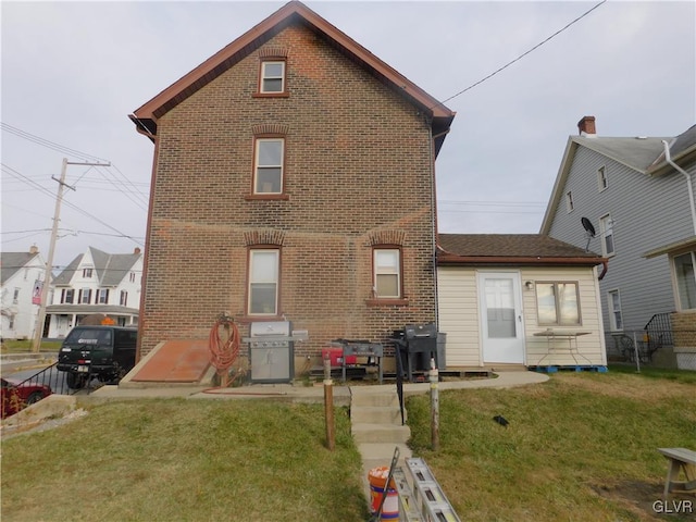 rear view of house featuring a lawn