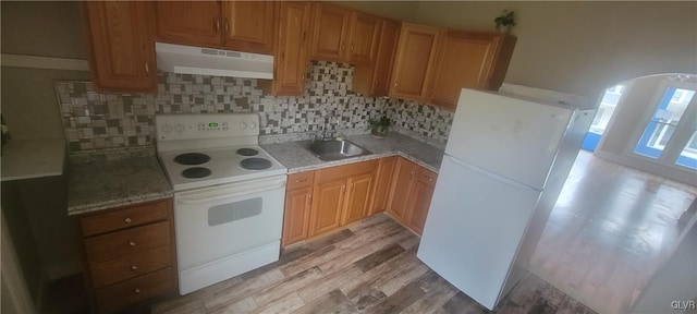 kitchen with decorative backsplash, white appliances, light hardwood / wood-style flooring, and sink