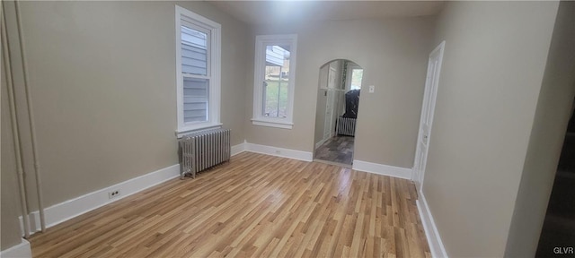 unfurnished room featuring light wood-type flooring and radiator