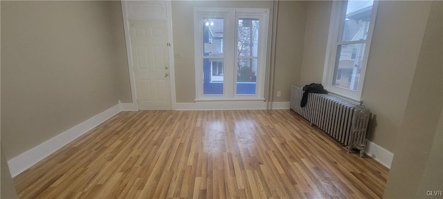 interior space with light wood-type flooring and radiator heating unit