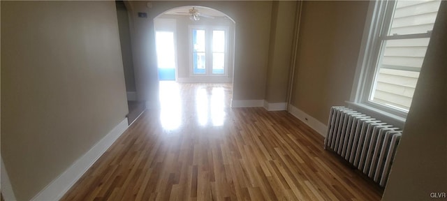 corridor with light hardwood / wood-style floors and radiator