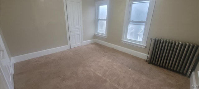 carpeted spare room with radiator heating unit