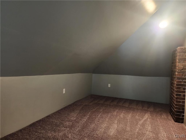 additional living space with carpet floors and vaulted ceiling