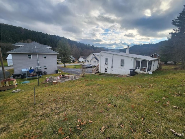 back of property featuring a lawn and a sunroom