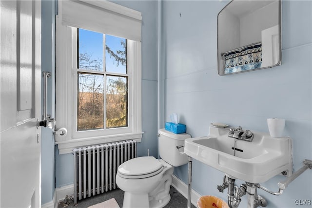 bathroom with radiator, sink, plenty of natural light, and toilet