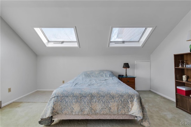 bedroom with multiple windows, light carpet, and vaulted ceiling with skylight