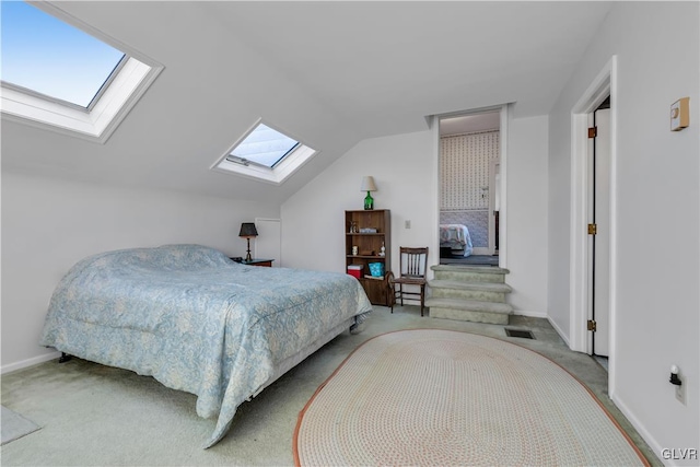 carpeted bedroom featuring vaulted ceiling with skylight