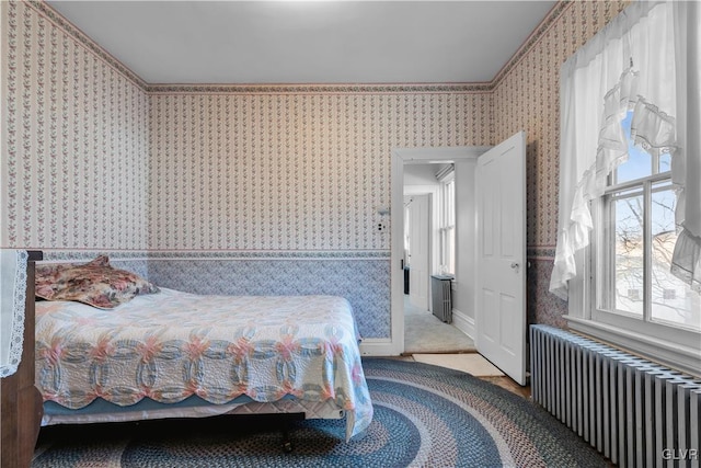 bedroom with radiator, carpet floors, and multiple windows