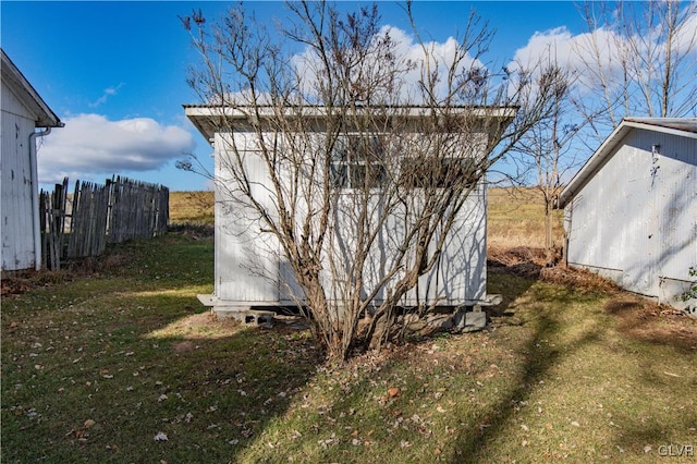 view of side of home featuring a storage unit and a lawn