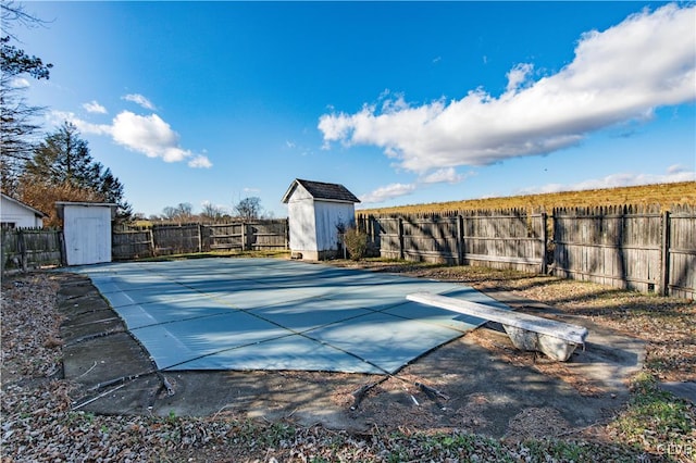 view of pool with a shed and a diving board