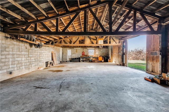 interior space featuring concrete flooring and vaulted ceiling