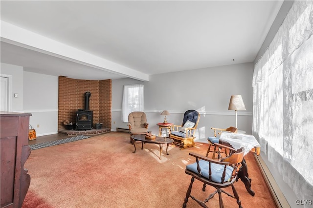 living room featuring carpet flooring, beam ceiling, a wood stove, and baseboard heating