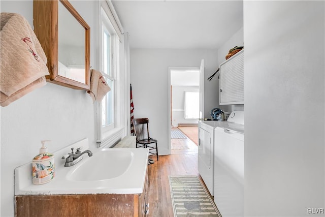 bathroom with sink, hardwood / wood-style flooring, and washing machine and clothes dryer