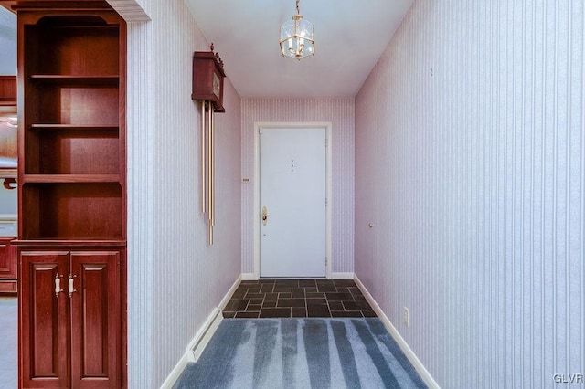 entryway with built in shelves and dark tile patterned flooring