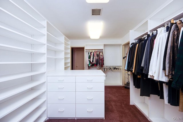 walk in closet featuring dark colored carpet