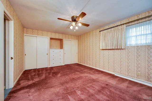 unfurnished bedroom with carpet flooring, ceiling fan, baseboard heating, and multiple closets