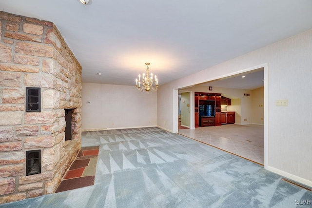 unfurnished living room featuring carpet, a fireplace, and a chandelier