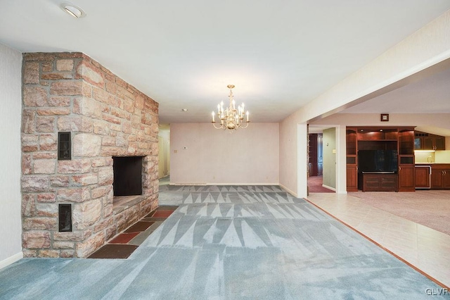 unfurnished living room featuring dark colored carpet, a stone fireplace, and a notable chandelier