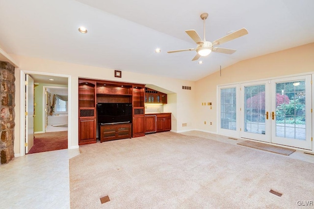 unfurnished living room featuring ceiling fan, french doors, light carpet, and lofted ceiling