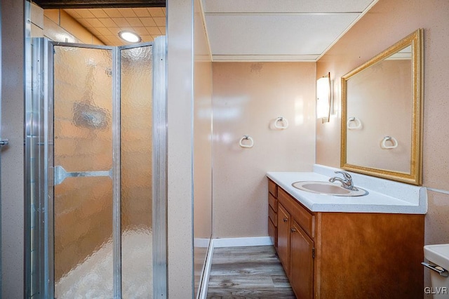 bathroom with hardwood / wood-style floors, vanity, toilet, and a shower with door