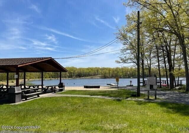 surrounding community with a gazebo, a yard, and a water view