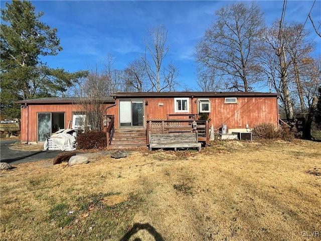 rear view of property with a lawn and a deck