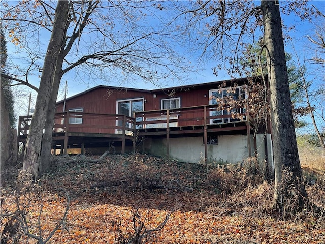 rear view of property featuring a wooden deck