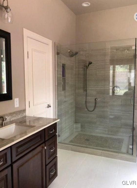 bathroom with tile patterned flooring, vanity, and an enclosed shower