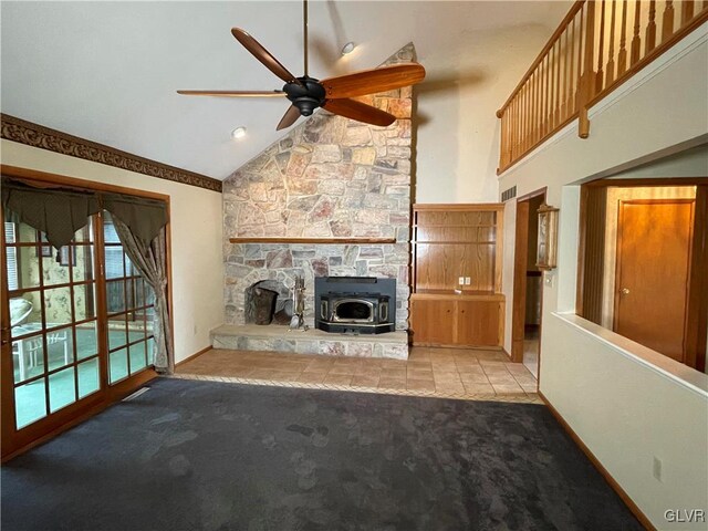 unfurnished living room with a wood stove, ceiling fan, high vaulted ceiling, and light colored carpet