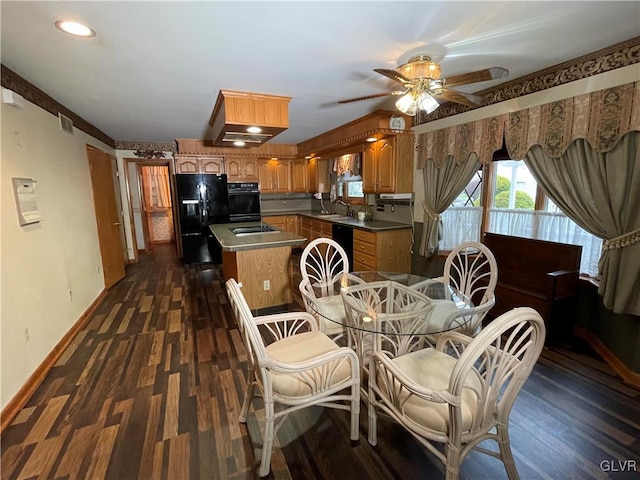 dining room featuring dark hardwood / wood-style floors, ceiling fan, and sink