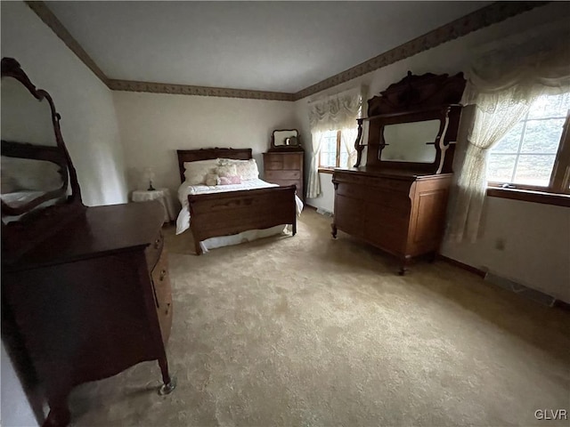 bedroom with light colored carpet and crown molding