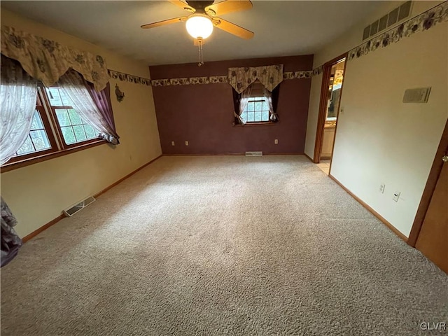 carpeted spare room featuring ceiling fan