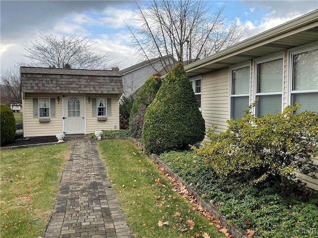 exterior space with an outbuilding and a front lawn