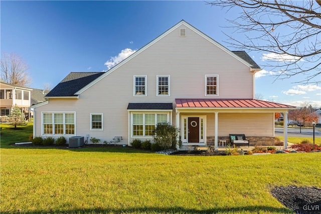 back of house with cooling unit and a lawn