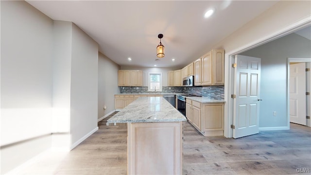 kitchen featuring a kitchen island, light brown cabinets, appliances with stainless steel finishes, and light hardwood / wood-style flooring