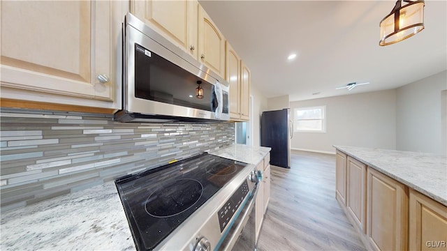 kitchen with decorative backsplash, light brown cabinetry, stainless steel appliances, decorative light fixtures, and light hardwood / wood-style flooring