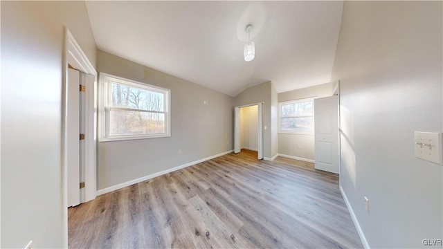 unfurnished bedroom with light hardwood / wood-style floors and lofted ceiling