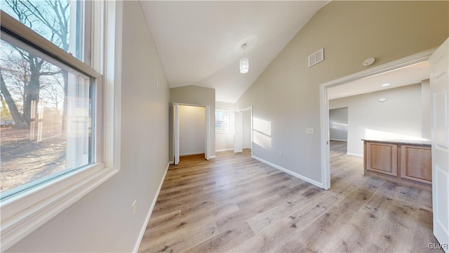 interior space with light wood-type flooring, high vaulted ceiling, and plenty of natural light