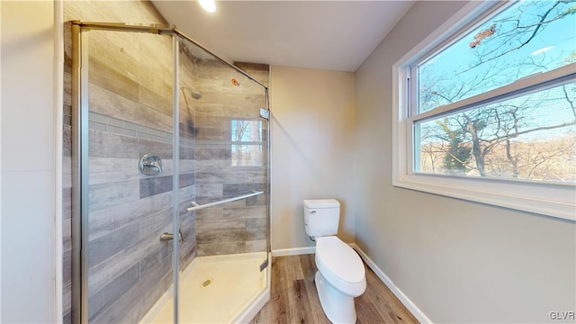 bathroom with hardwood / wood-style floors, toilet, and walk in shower