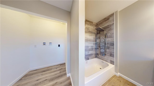 bathroom with hardwood / wood-style floors and tiled shower / bath combo