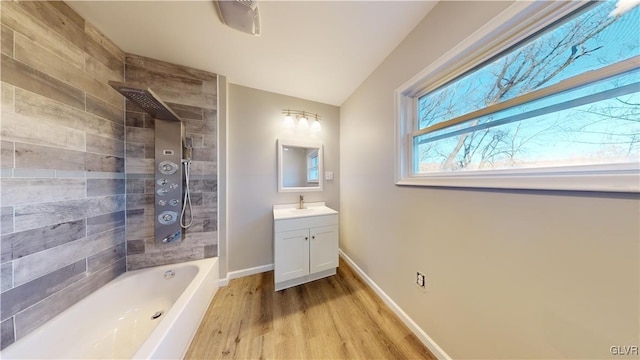 bathroom with vanity, wood-type flooring, lofted ceiling, and tiled shower / bath