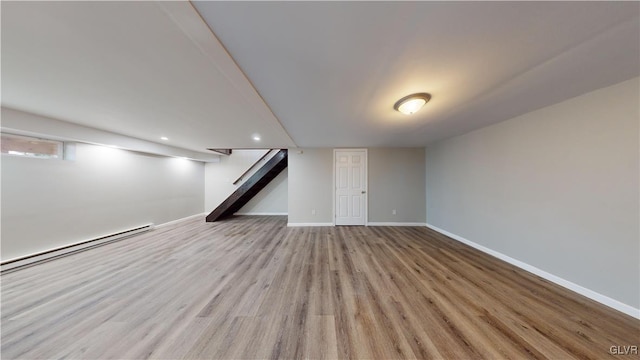 basement featuring a baseboard radiator and light wood-type flooring