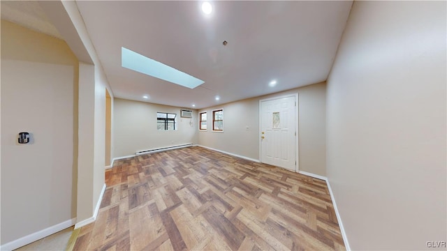 interior space featuring baseboard heating, a wall mounted AC, and light hardwood / wood-style flooring