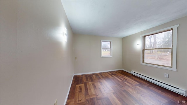 empty room featuring baseboard heating and dark wood-type flooring