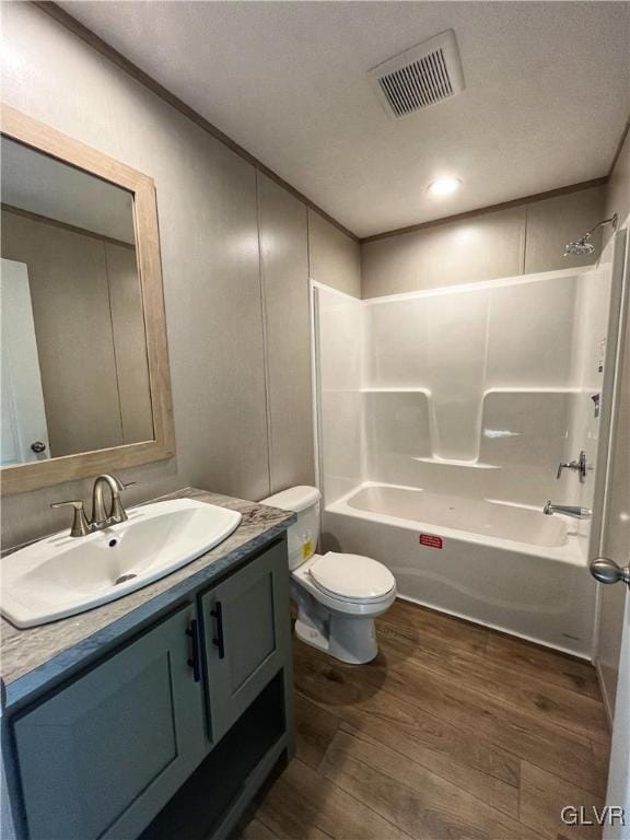 full bathroom featuring shower / bathing tub combination, vanity, hardwood / wood-style flooring, and toilet