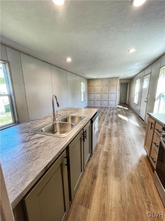 kitchen with light hardwood / wood-style floors, sink, a textured ceiling, and stainless steel appliances