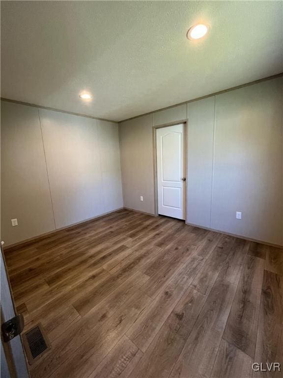 empty room featuring a textured ceiling and hardwood / wood-style flooring