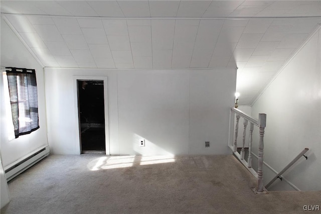 unfurnished room featuring carpet flooring, crown molding, and a baseboard heating unit